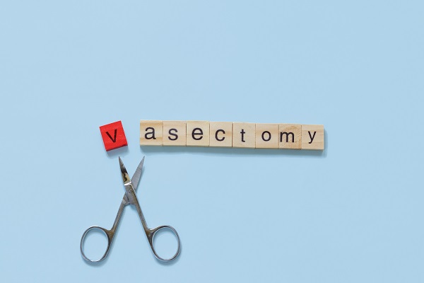 Tiles spelling the word vasectomy with scissors poised to snip the v tile